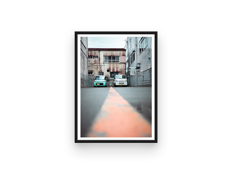 2 parked cars in an industrial looking area, in the streets of Japan