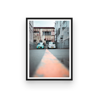 2 parked cars in an industrial looking area, in the streets of Japan